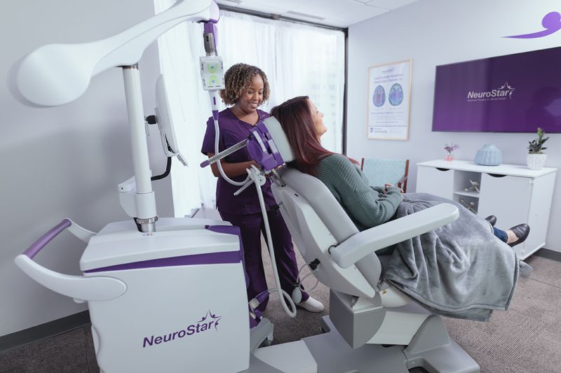 Image of patient sitting in a NeuroStar chair with treater